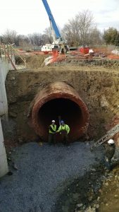 photo of construction workers in water pipe